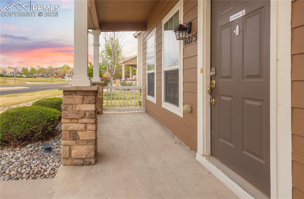 Image 4 of 33: Exterior entry at dusk with a porch
