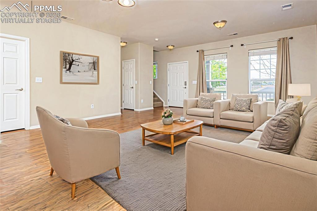 Image 6 of 33: Living area with light wood-style flooring and baseboards Virtually Staged