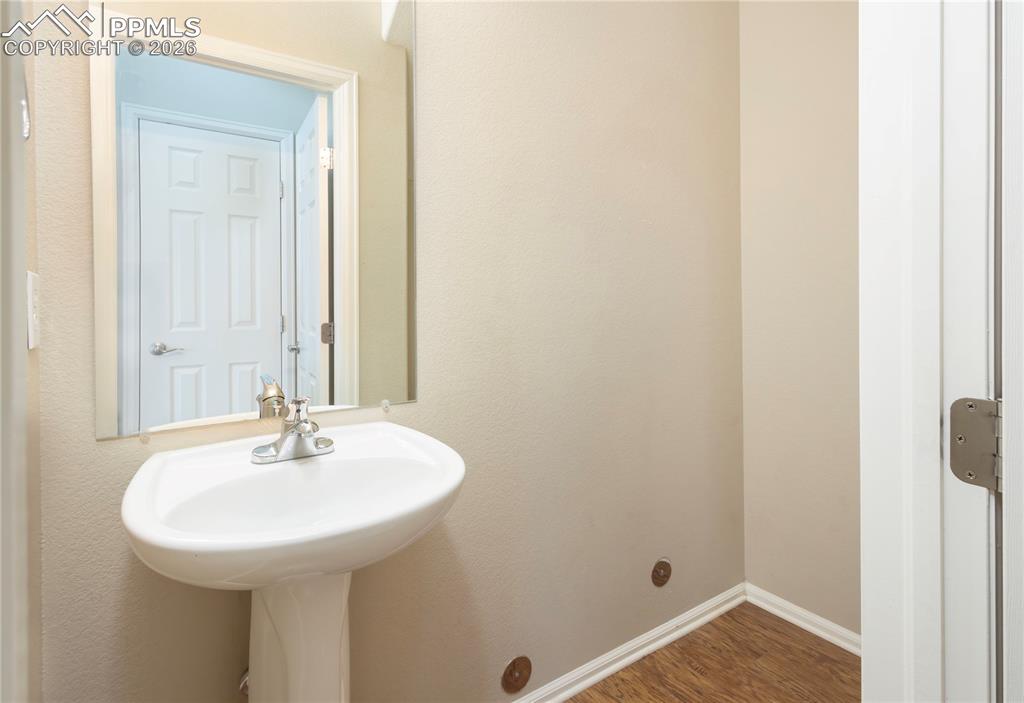 Image 7 of 33: Bathroom featuring dark wood-style flooring and baseboards
