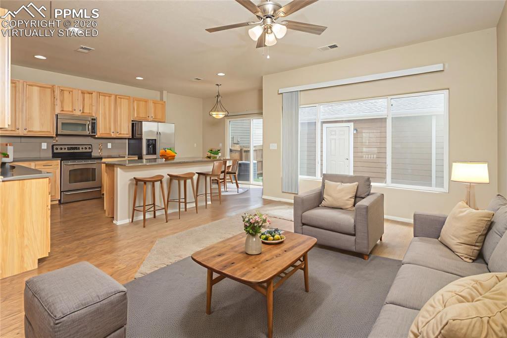 Image 8 of 33: Living area featuring a ceiling fan, recessed lighting, and light wood fini