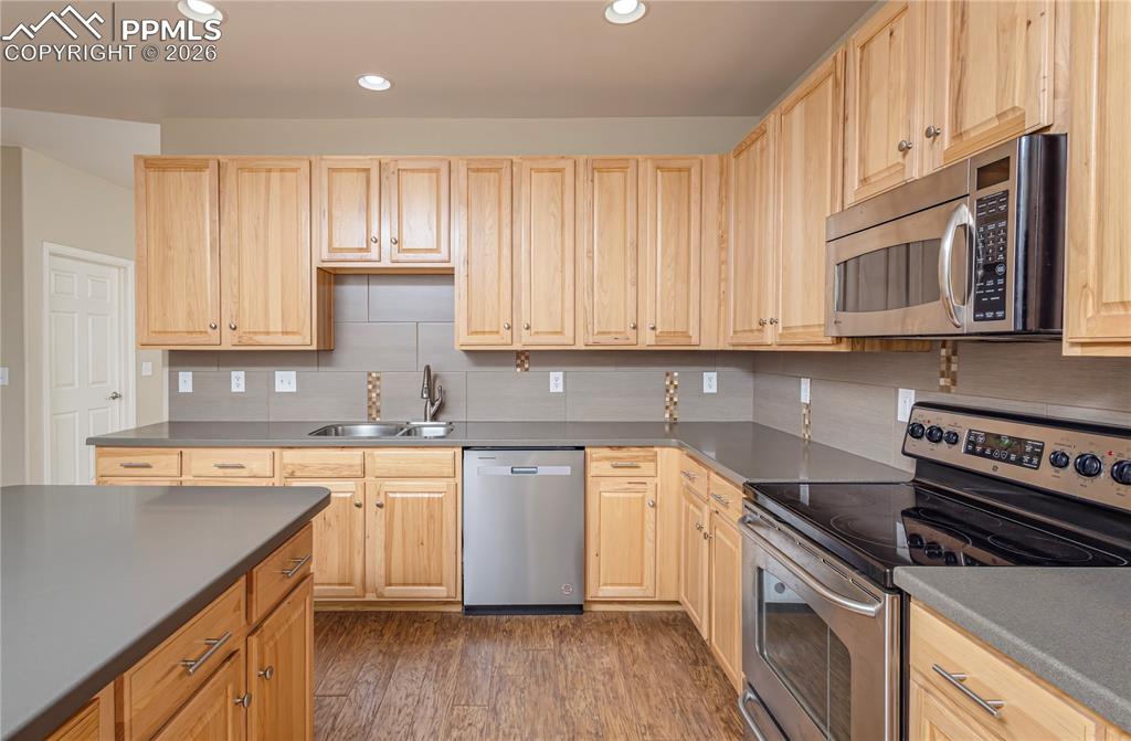 Image 9 of 33: Kitchen featuring stainless steel appliances, light wood finish cabinets, d