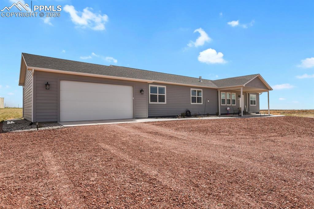 Caption: Gray siding exterior featuring a covered front porch and an attached two-car garage