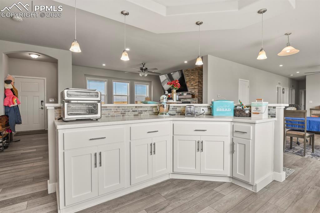 Image 11 of 48: Kitchen island featuring white shaker cabinetry, an integrated white counte