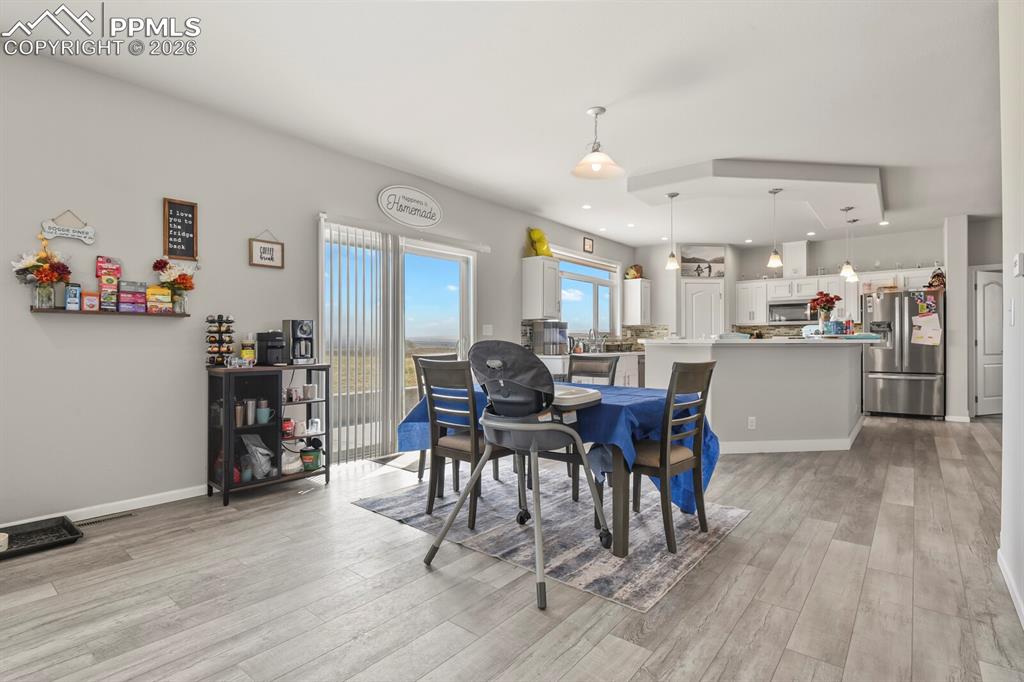 Image 12 of 48: Open-concept interior featuring light gray walls, wood-finish flooring, and