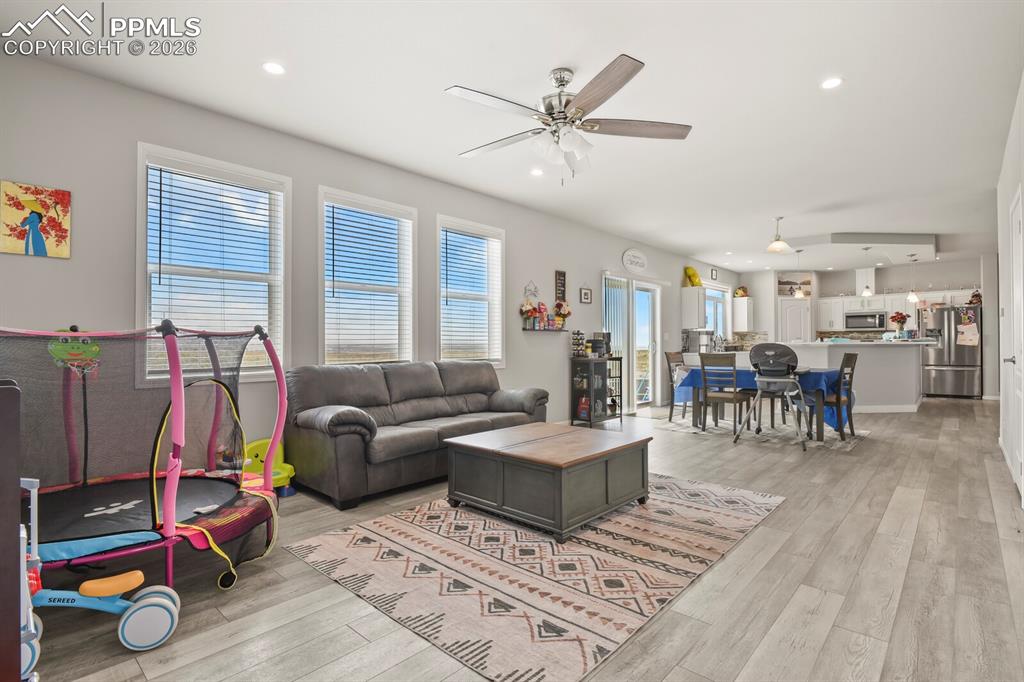 Image 14 of 48: Open-concept living space featuring light wood-finish flooring, recessed li