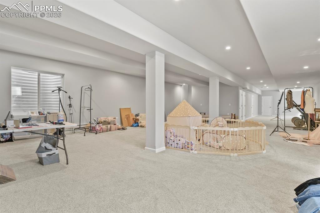 Image 29 of 48: Expansive carpeted area featuring recessed lighting, support columns, and m