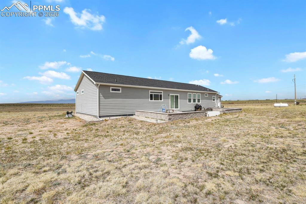 Image 35 of 48: Single-story residence featuring light gray siding, dark shingle roofing, a