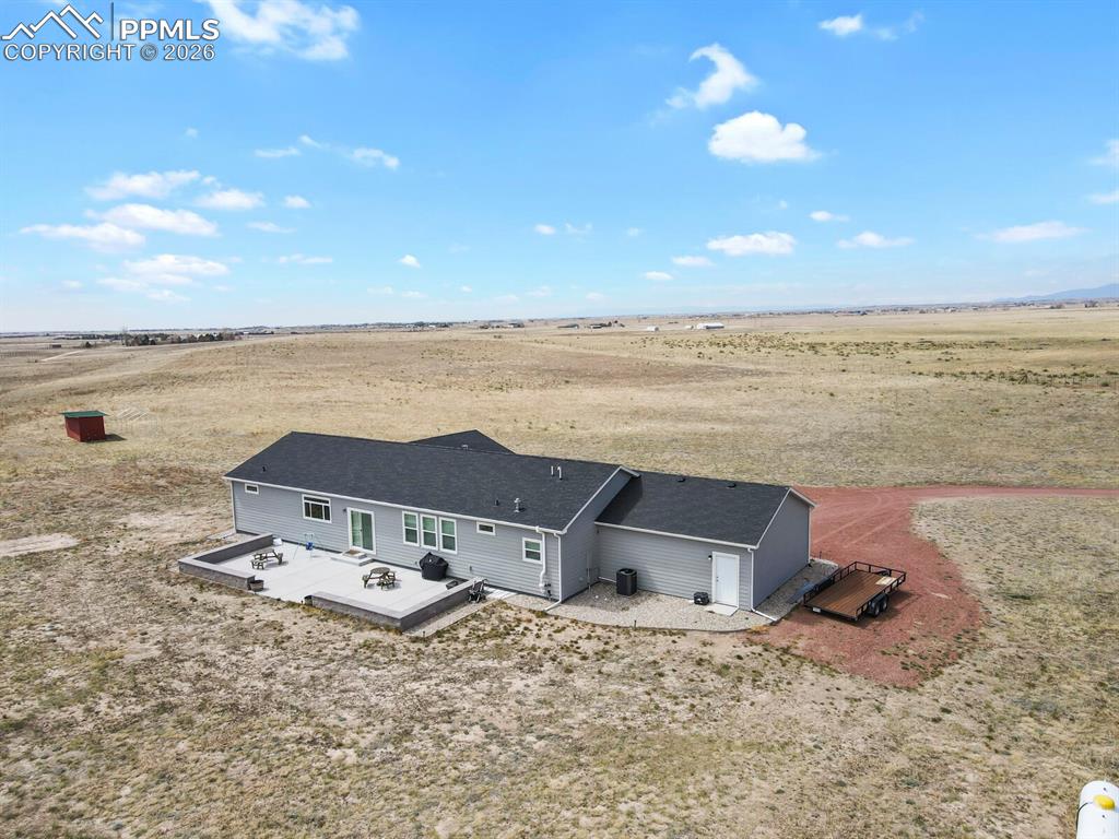 Image 41 of 48: Spacious property featuring a light gray exterior, dark shingle roof, and a