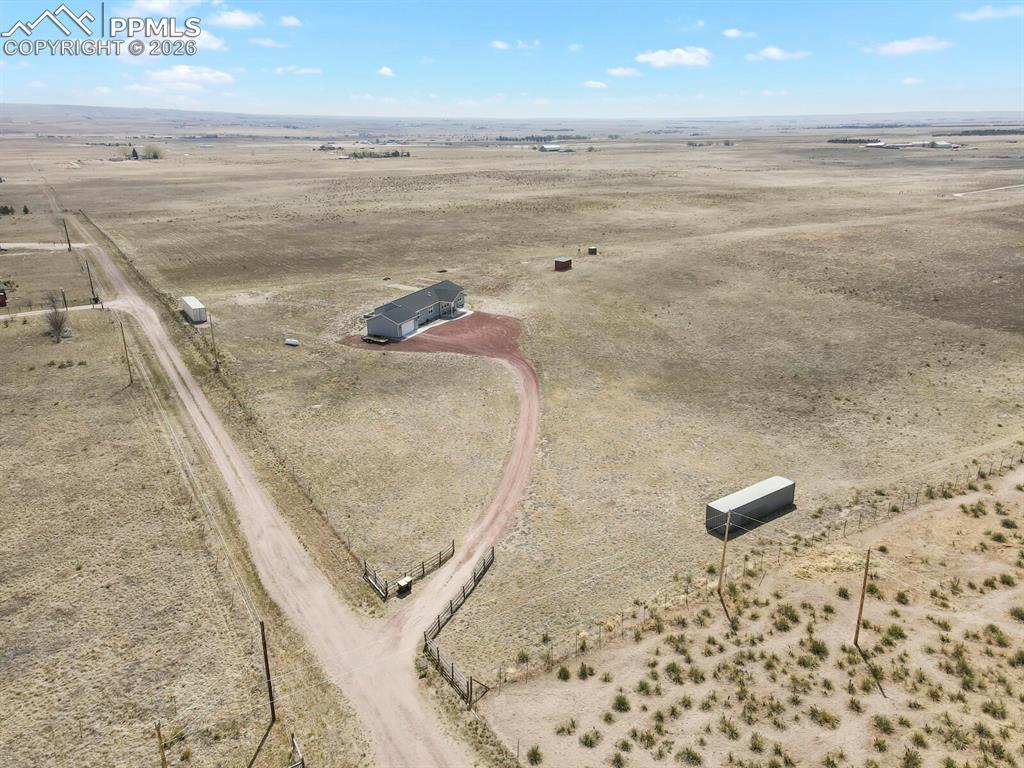 Image 48 of 48: Expansive arid landscape featuring a single-story residence with a gray roo