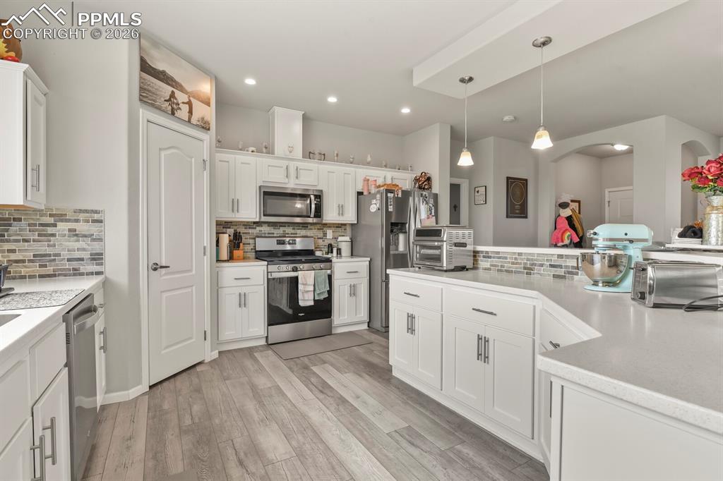 Image 9 of 48: Contemporary kitchen featuring white cabinetry, stainless steel appliances,