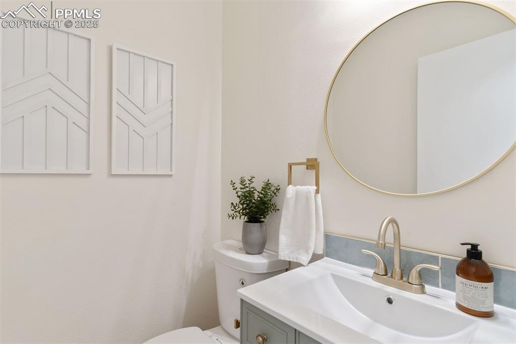 Image 8 of 37: Renovated powder room with brushed gold fixtures.