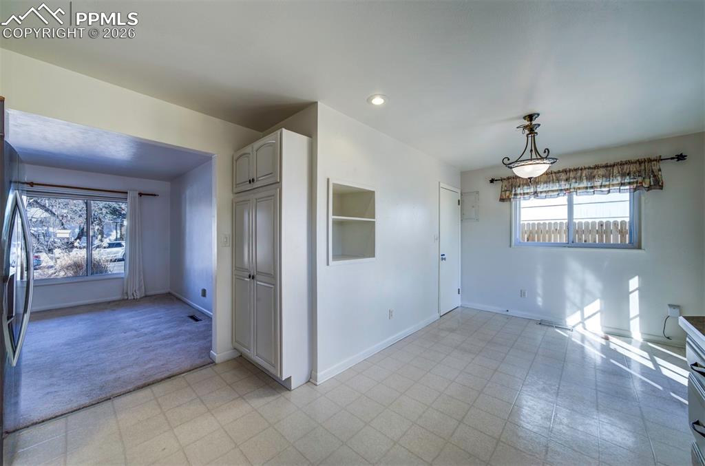 Image 13 of 40: Dine in area and living room, from kitchen sink area; showing pantry area t