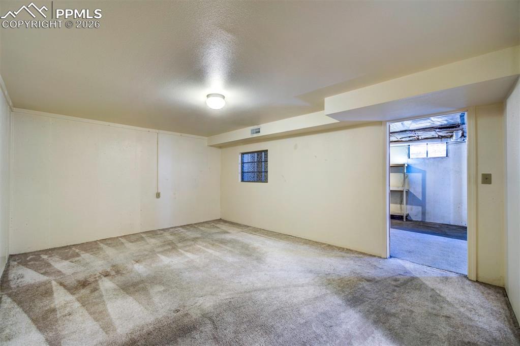 Image 30 of 40: Another view of the non-conforming bedroom and out into open basement/stora