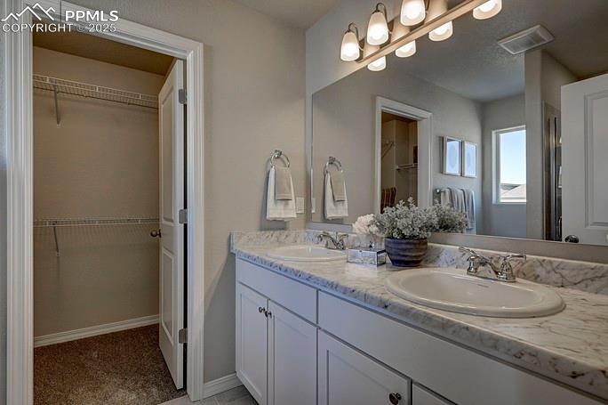 Image 19 of 21: Full bath with a walk in closet and double vanity