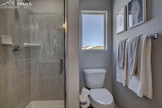 Image 20 of 21: Full bathroom featuring a stall shower and toilet
