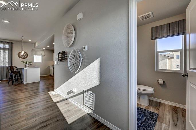 Image 3 of 21: Bathroom with healthy amount of natural light and dark wood-style flooring