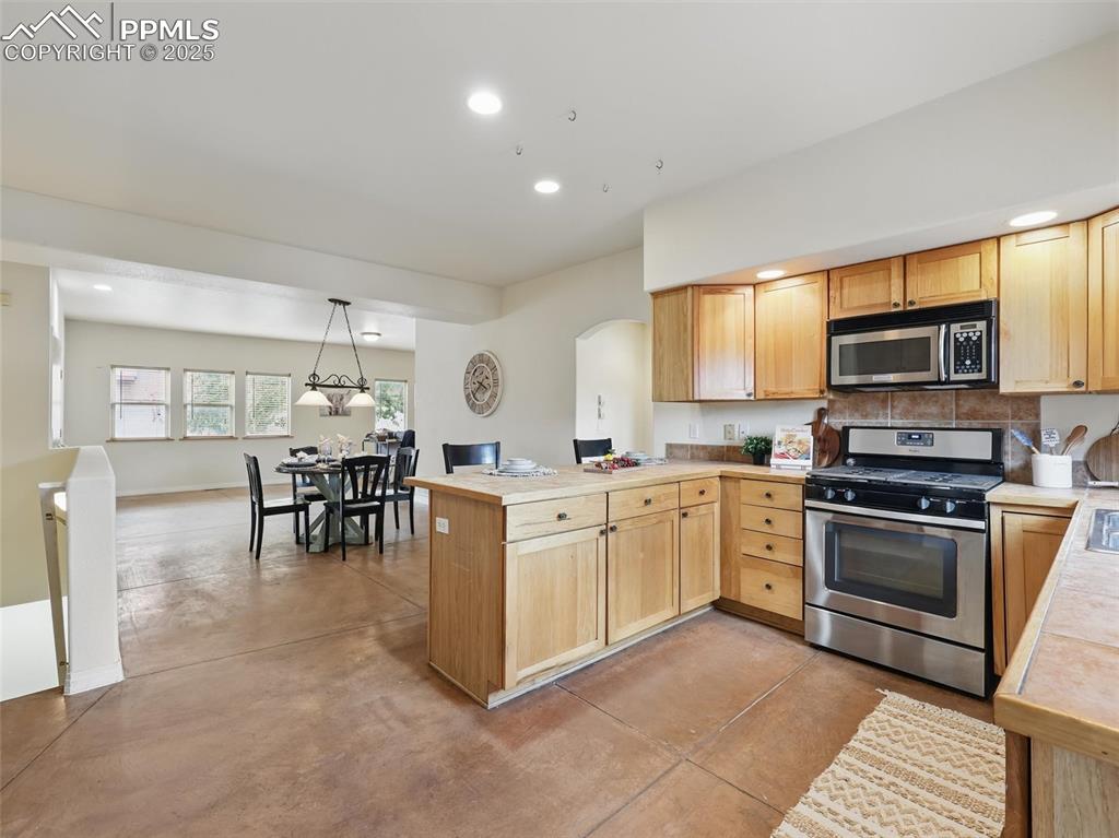 Image 12 of 41: Kitchen featuring stainless steel appliances, finished concrete floors, a p