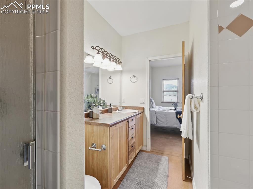 Image 16 of 41: Ensuite bathroom with vanity, a shower stall, and light wood-style flooring