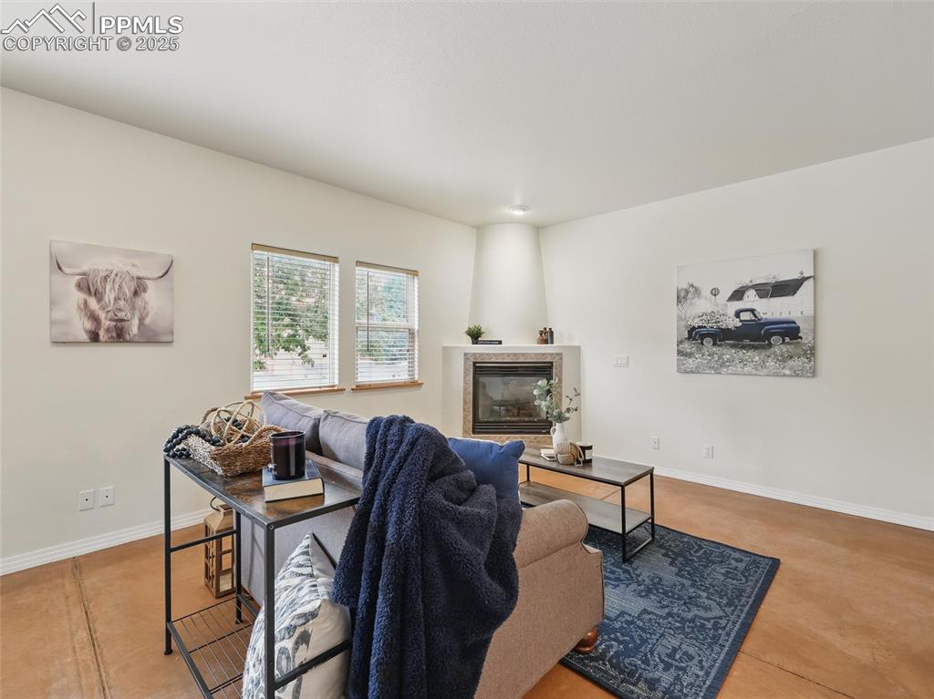 Image 19 of 41: Living area featuring baseboards and a tile fireplace