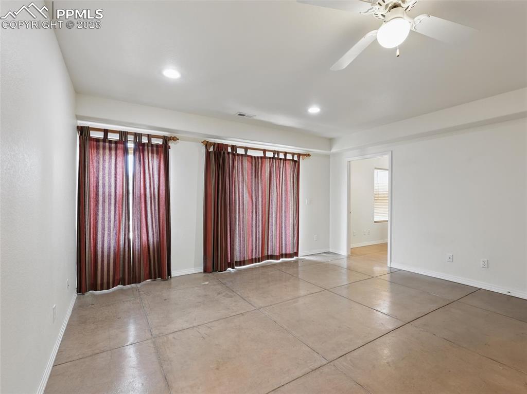 Image 25 of 41: Empty room with finished concrete floors, recessed lighting, and a ceiling 