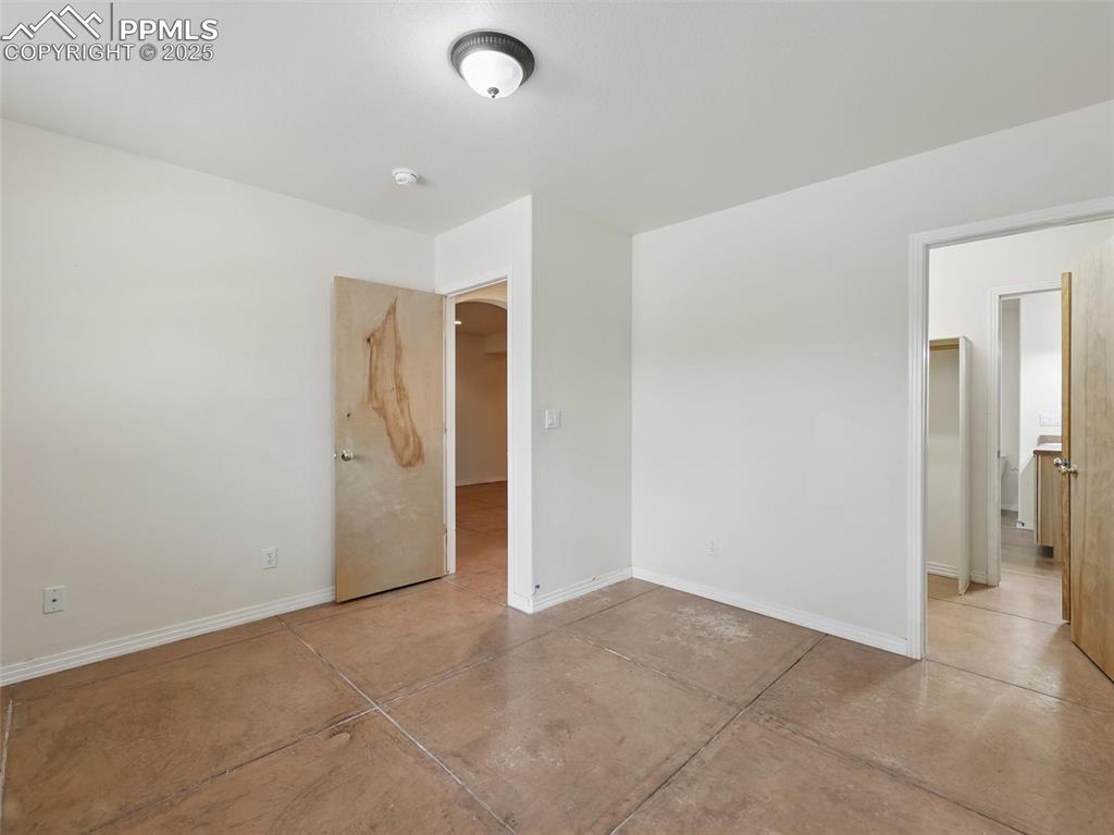 Image 32 of 41: Unfurnished bedroom featuring baseboards and concrete flooring