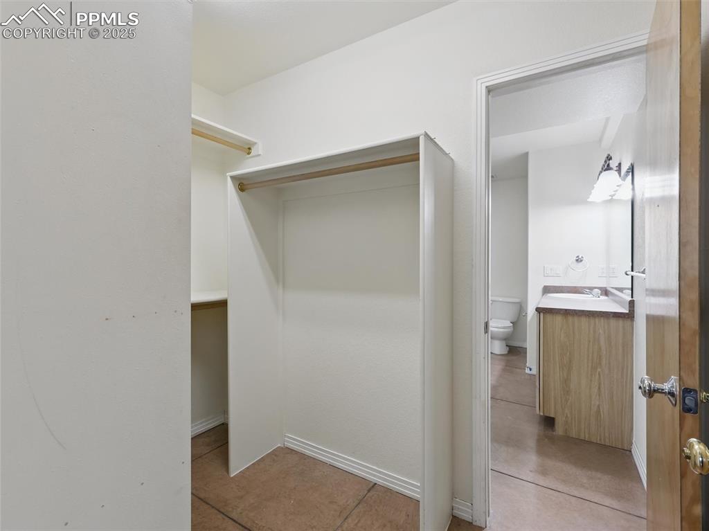 Image 33 of 41: Walk in closet with light tile patterned floors