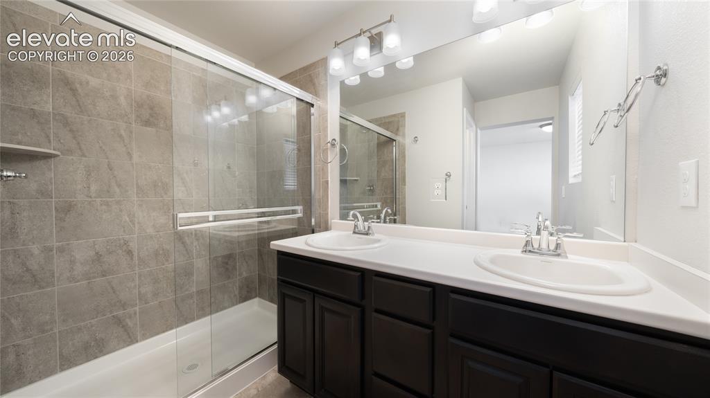 Image 10 of 13: Bathroom featuring a dual vanity with white countertops, dark wood-finish c