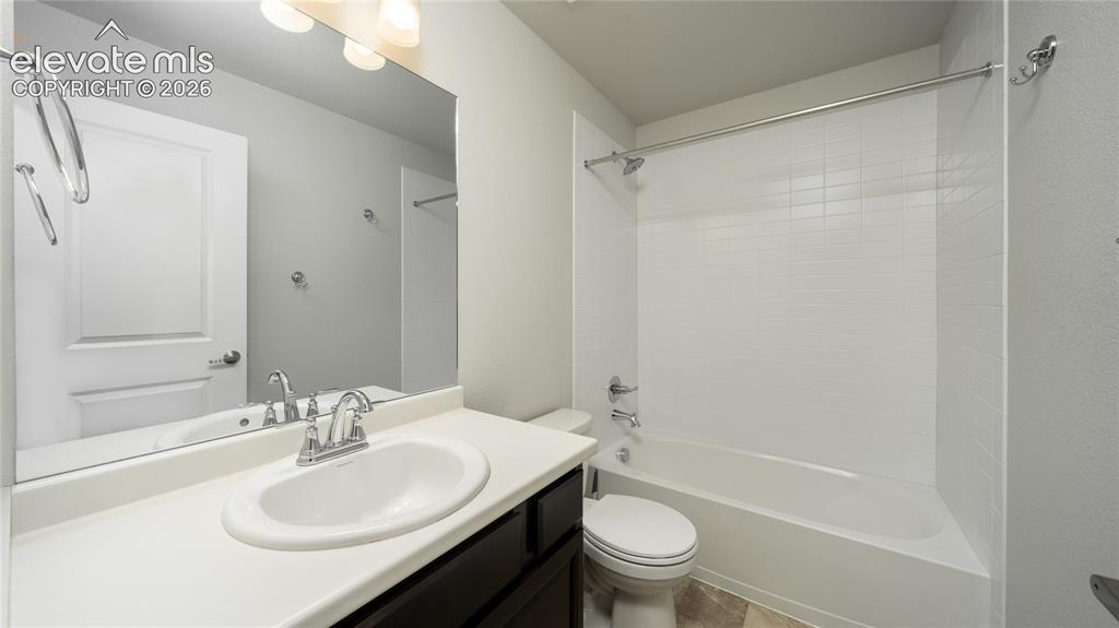 Image 12 of 13: Bathroom featuring a dark wood-finish vanity with a white countertop, an ov
