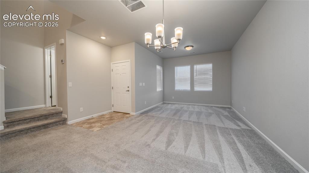 Image 2 of 13: Spacious interior featuring light gray walls, patterned carpeting, a multi-