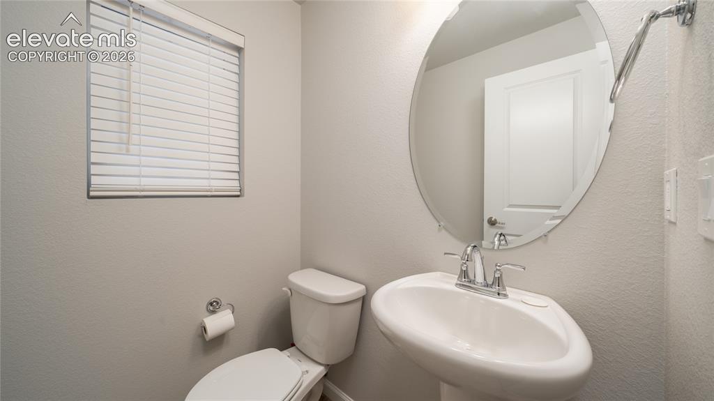 Image 6 of 13: Bathroom featuring a pedestal sink with chrome faucet, an oval mirror, and 