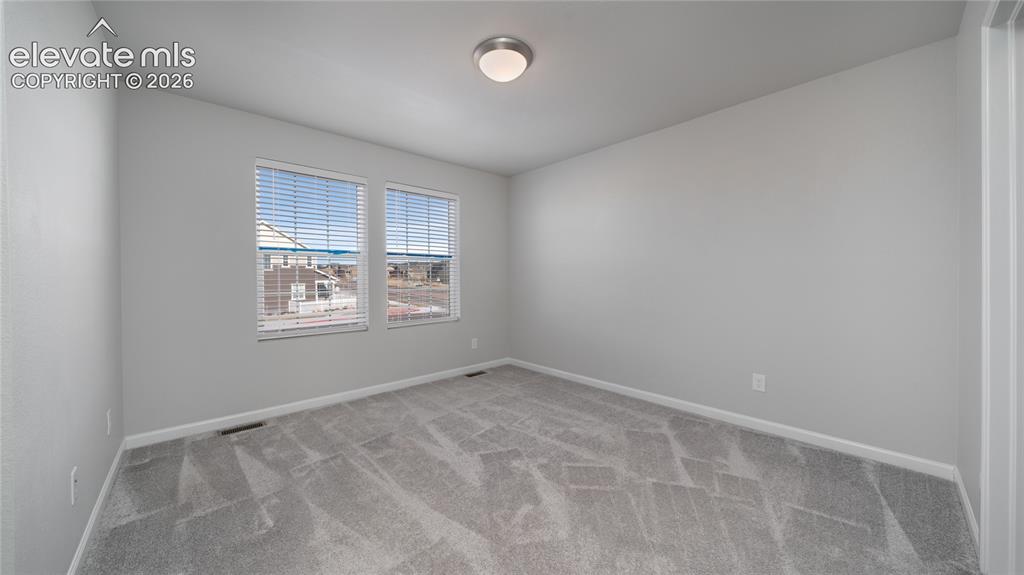 Image 8 of 13: Neutral-toned room featuring light gray walls, gray patterned carpeting, an