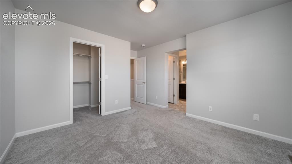 Image 9 of 13: Carpeted room with a ceiling-mounted light fixture, white trim, and a close