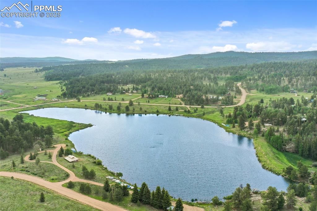 Image 27 of 30: Drone / aerial view of a heavily wooded area and a water and mountain view