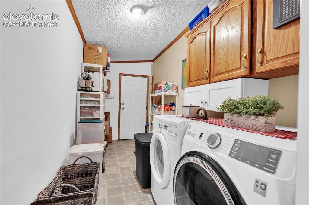 Image 11 of 36: Utility room featuring wood-finish wall trim, overhead wood-finish cabinetr