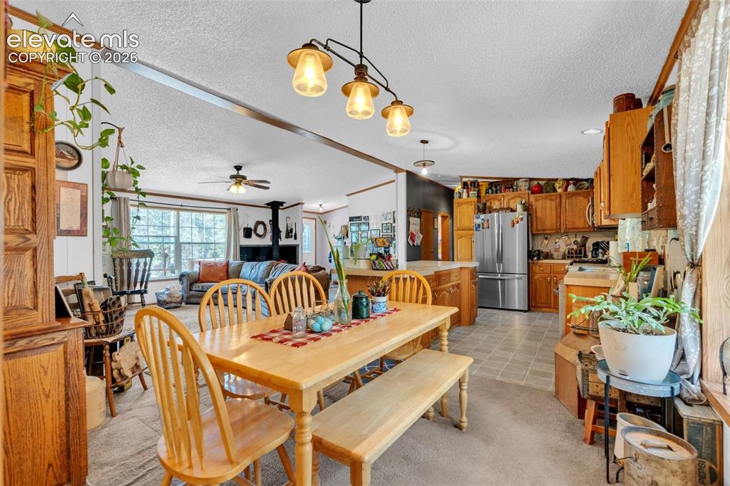 Image 12 of 36: Open-concept dining area with wood-finish flooring, a contemporary chandeli
