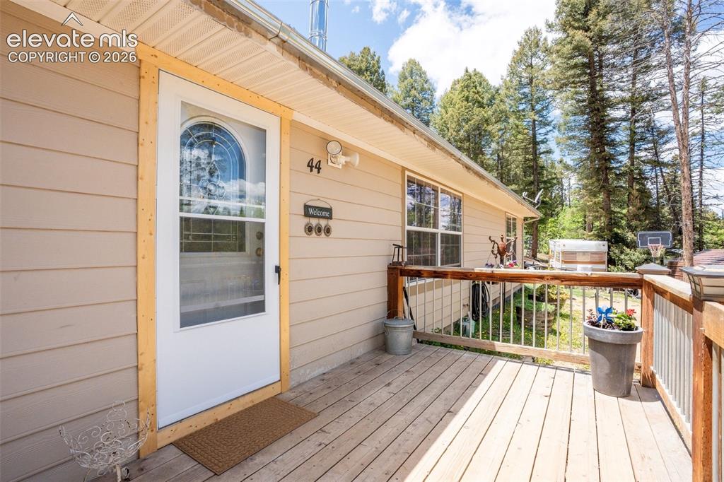 Image 13 of 36: Front deck with wood flooring and a wooden railing system