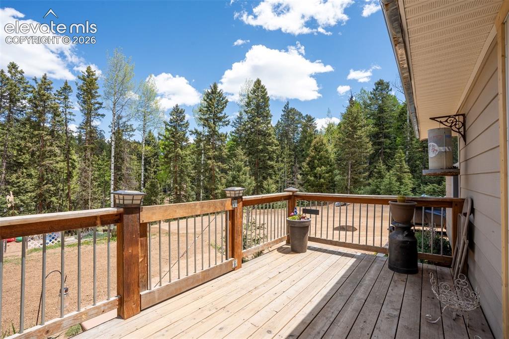 Image 14 of 36: Expansive wood deck with a natural finish, featuring a wood railing with me
