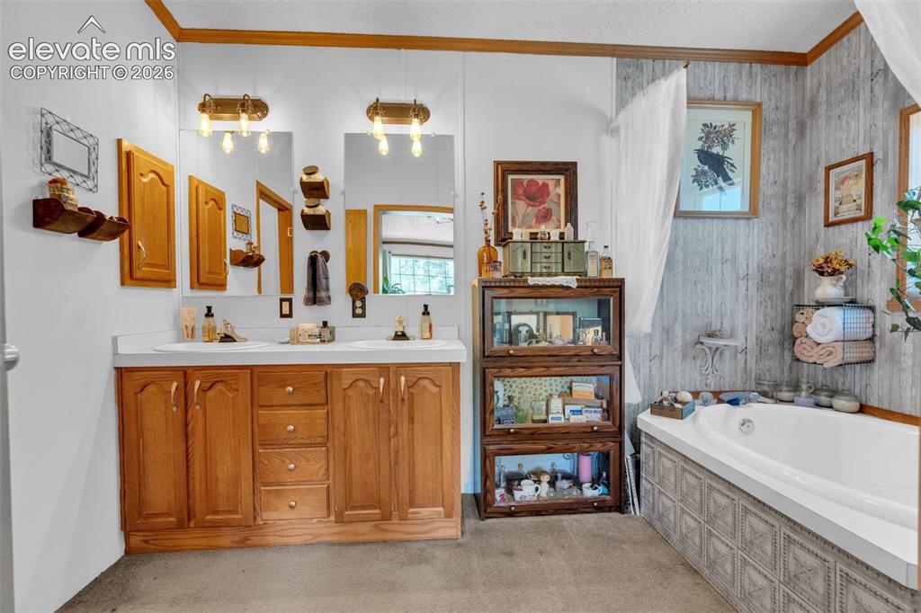 Image 20 of 36: Bathroom featuring a dual vanity with wood cabinetry, a white countertop, a