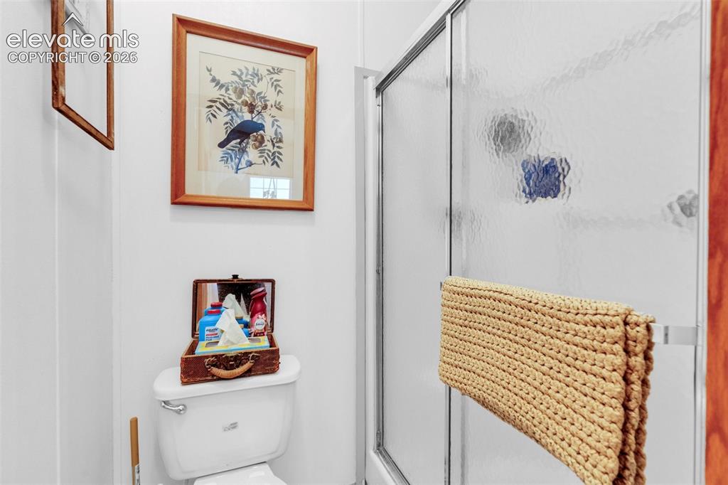 Image 22 of 36: Enclosed shower with textured glass panels, chrome hardware, and a white to