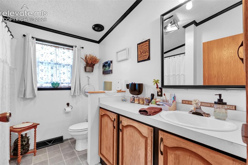 Image 23 of 36: Bathroom featuring a single window, white walls with black trim, a vanity w