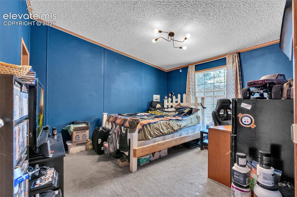 Image 25 of 36: Room featuring textured ceiling, wood-finish trim, and paneling