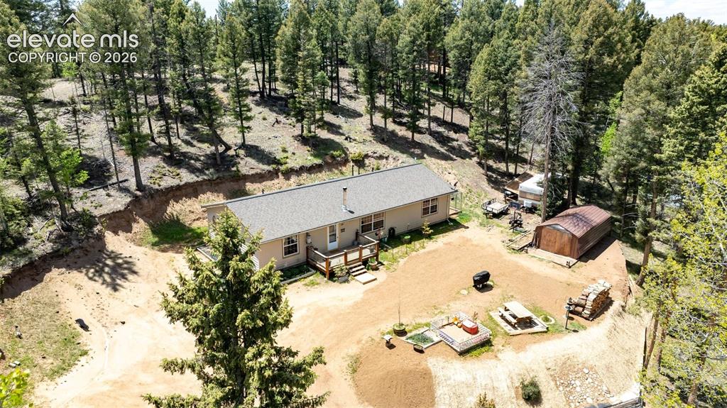 Image 28 of 36: Ranch-style residence featuring a light-colored exterior and a gray asphalt