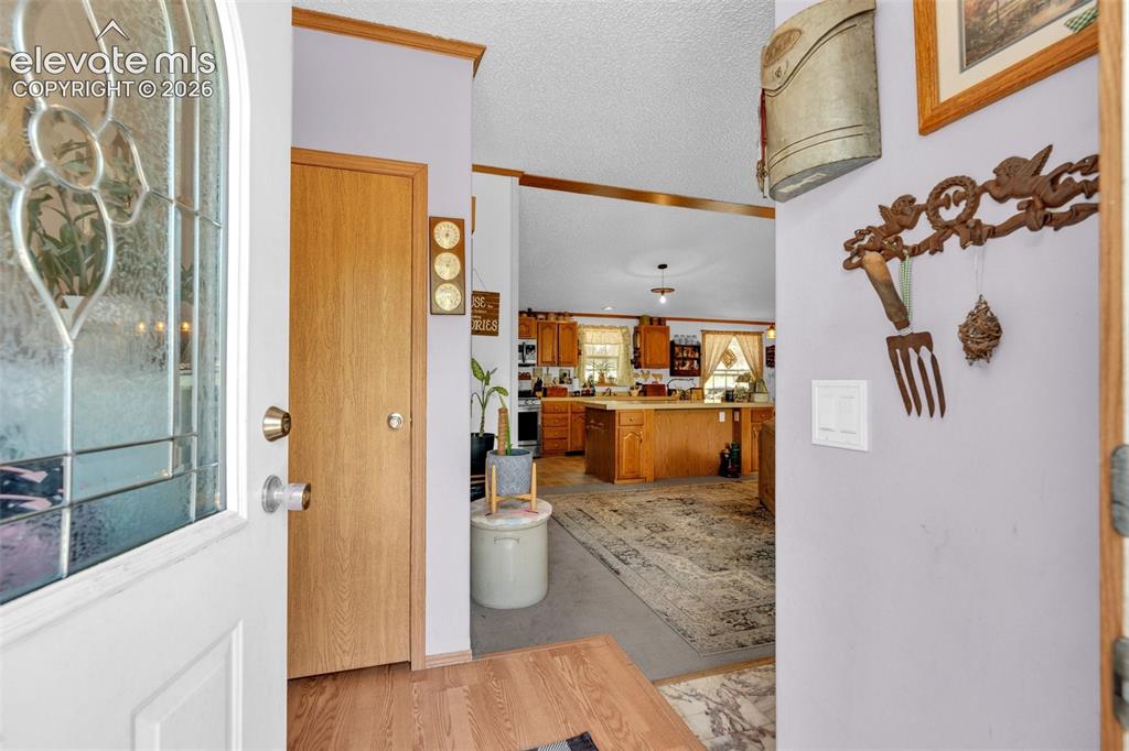 Image 3 of 36: Entryway featuring a decorative glass paneled door, wood-finish flooring, a