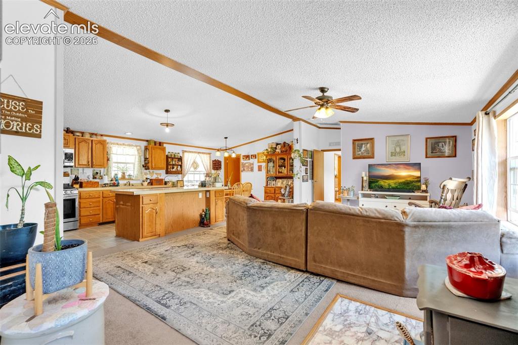 Image 4 of 36: Open-concept living space featuring wood-finish ceiling beams and a ceiling