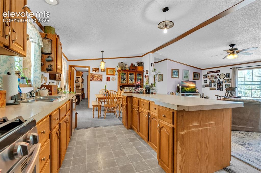 Image 9 of 36: Kitchen featuring wood cabinetry, a stainless steel range, and a double bas