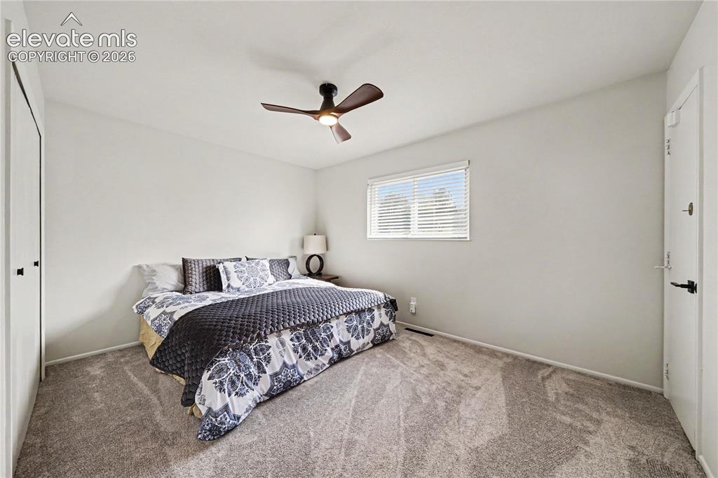 Image 10 of 22: Main carpeted bedroom featuring a ceiling fan with integrated lighting, a w