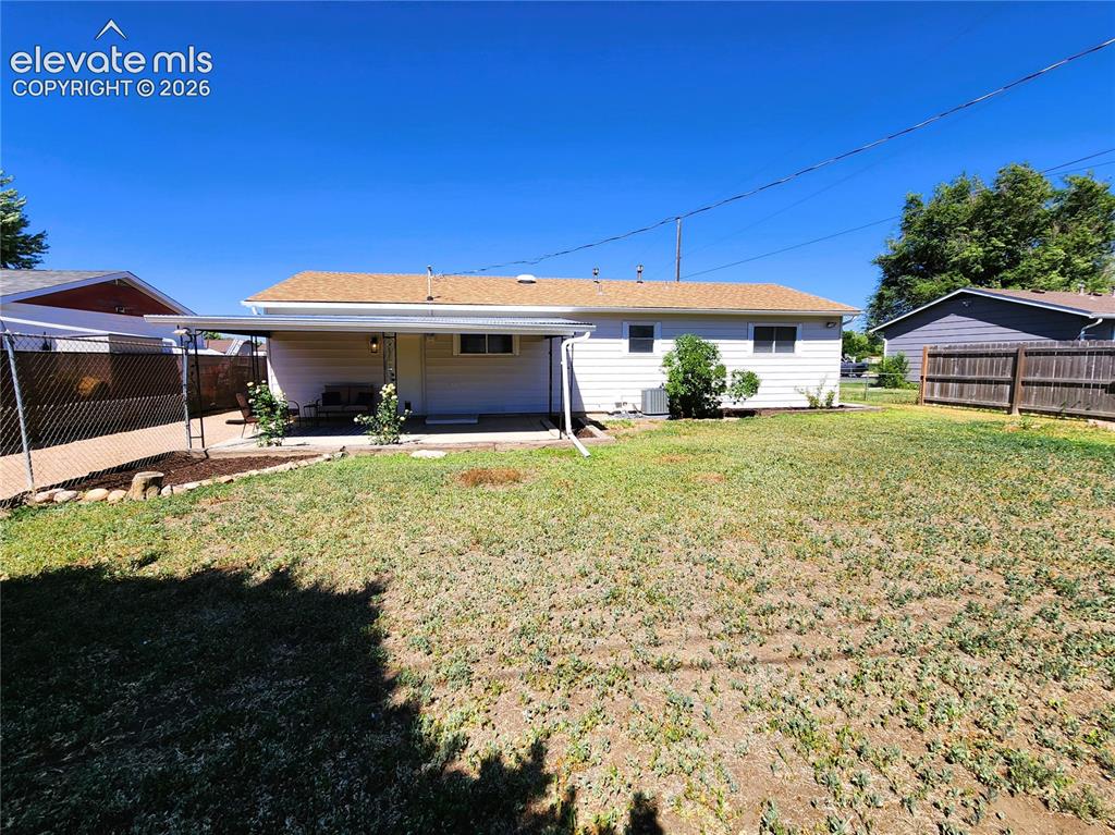 Image 13 of 18: Side yard, Large covered patio, and large fenced in yard.