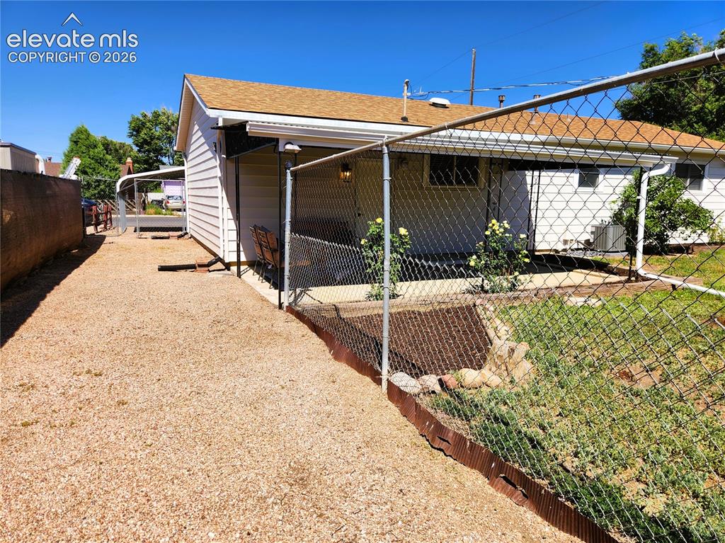 Image 15 of 18: Side yard accessible from driveway for toys, also can be used as a fenced i