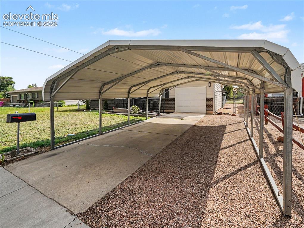 Image 16 of 18: Carport comfortably accomodates 2 cars or trucks.