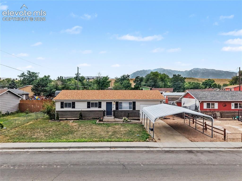 Image 2 of 22: Ranch-style residence featuring a carport and front porch